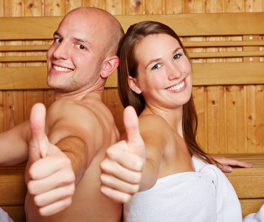 Paar zeigt Daumen hoch in Sauna