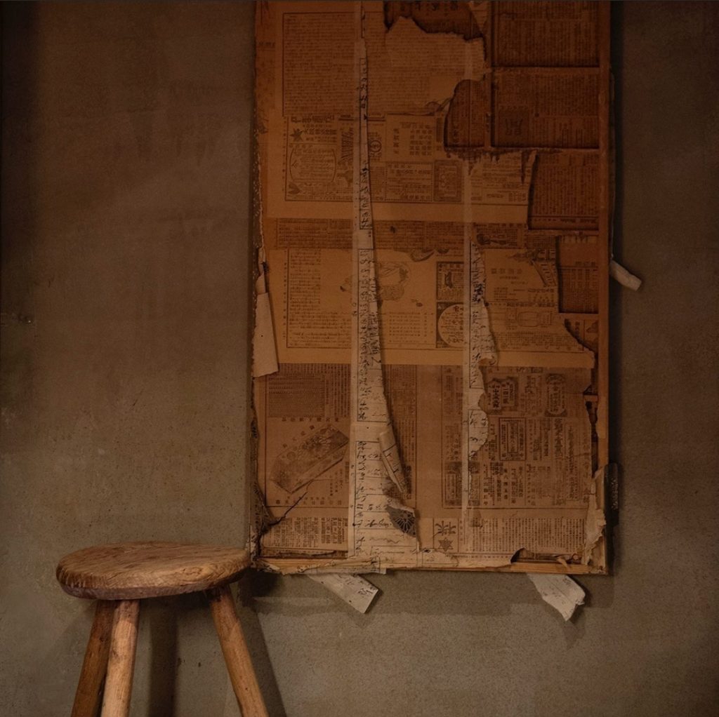 Starý roztrhaný plagát na stene vedľa drevenej stoličky